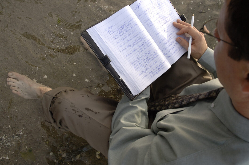 a man with a notebook on the beach